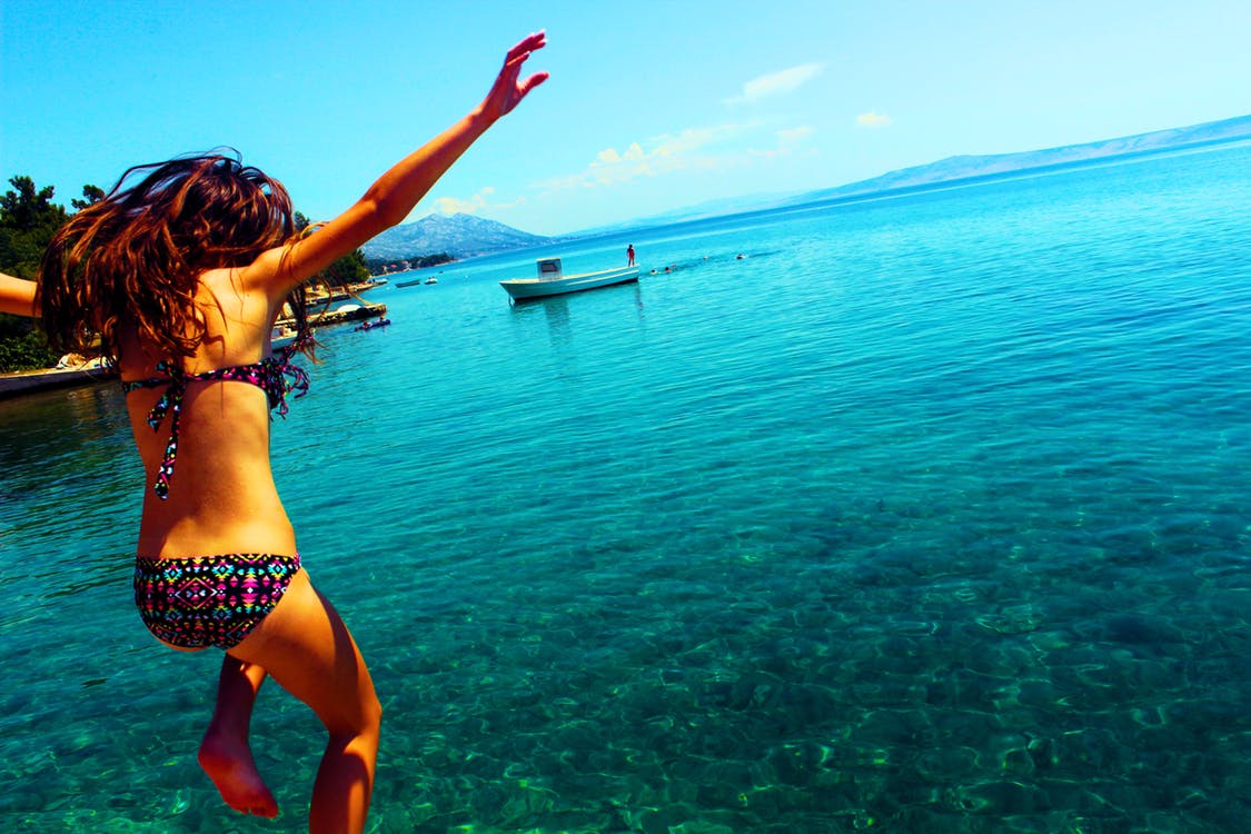 Ragazza che si tuffa in un mare blu